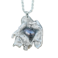 A pendant with a dark pearl in the center. 