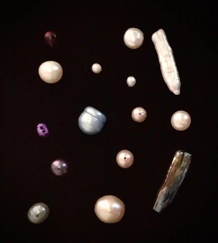 An image of various kinds of pearls on a black background.