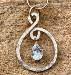An image of a pendant with a natural stone in the center.