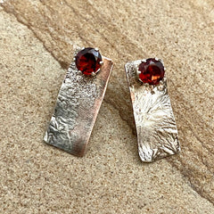 Rectangular silver earrings with garnet stones in the top-center.